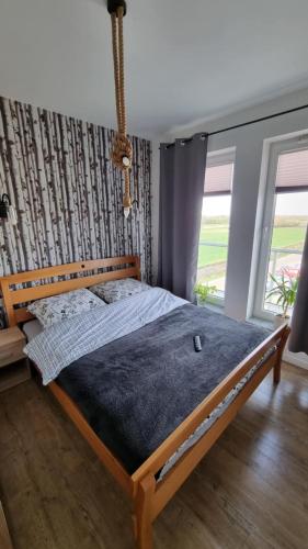 a bed in a bedroom with a large window at Apartament Bianco - Aquapark in Rumia