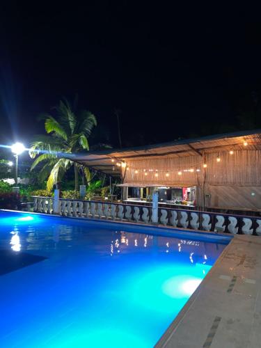 a swimming pool in front of a building at night at Villa Del Mar in Turbo