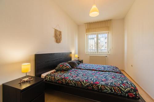 a bedroom with a bed and a table with a lamp at Flexible SelfCheckIns 47 - Zagreb - Two Loggia - New - 3 Bedrooms - 2 WC in Zagreb