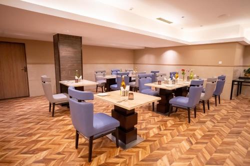 a dining room with tables and chairs at ASTER GRAND BY ZENQ Saket in New Delhi