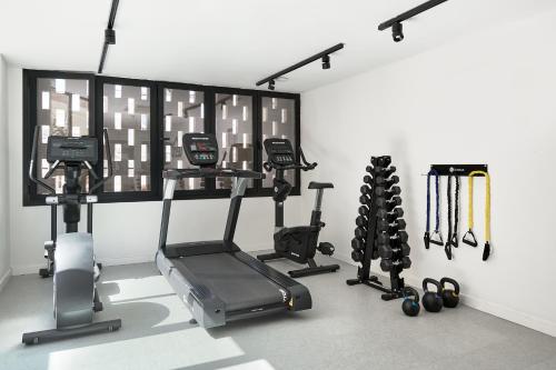 a room with a gym with a treadmill and weights at tent Capi Playa in Playa de Palma