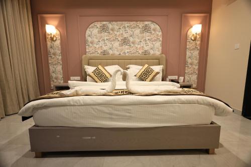 a bedroom with a large bed with two swans on it at Krishna Resort Pushkar in Pushkar