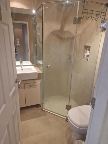 a bathroom with a shower and a toilet and a sink at Cristians lägenhet in Kata Beach