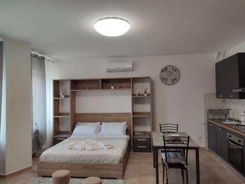 a bedroom with a bed and a table and a clock at Vera Alloggio Alessandria nr2 in Alessandria