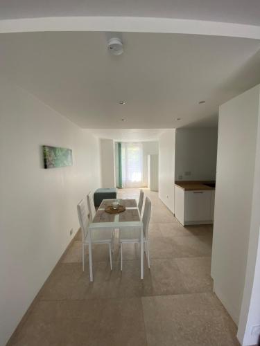 une salle à manger blanche avec une table et des chaises dans l'établissement Balneo Clim Terrasse et Parking Relaxation Guarantie, à Fréjus