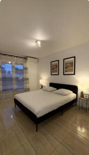 une chambre avec un grand lit dans une pièce dans l'établissement L'Etoile à deux pas de la mer, à Boulouris-sur-Mer