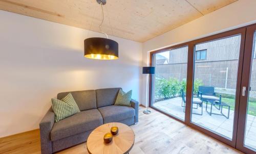 a living room with a couch and a table at Urban-Apartmenthaus zwischen Berg und See in Dornbirn