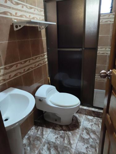 a bathroom with a toilet and a sink and a shower at Hostal Río Escondido Santa Fe in Santa Fé