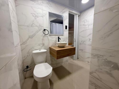 a bathroom with a toilet and a sink and a mirror at Casa Fama in San Andrés