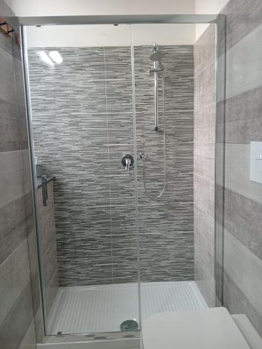 une douche avec une porte vitrée et des toilettes dans l'établissement Monsoleil, à Reggio de Calabre