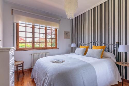 a bedroom with a large white bed with yellow pillows at Villa Glicinia in Viveda