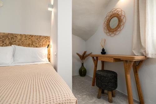 a bedroom with a bed and a table with a mirror at Sea & Sun Paros in Naousa