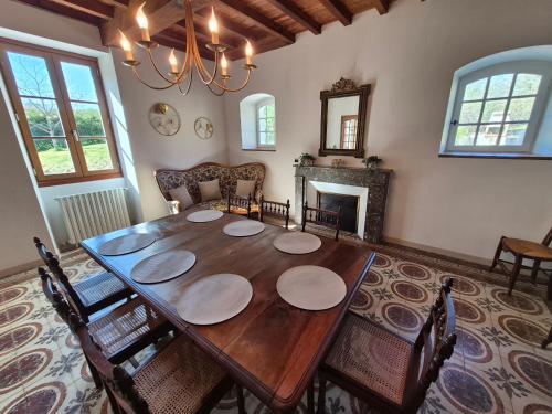 AubertinにあるCharmante maison - Terrasse, Piscine - Près de Pauのダイニングルーム(木製テーブル、暖炉付)