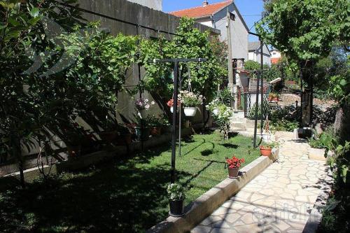 a garden with plants and flowers in a yard at Apartman Bepino terasa&parking in Pirovac