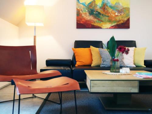 a living room with a couch and a table at SEE & THE CITY apartments in St. Wolfgang