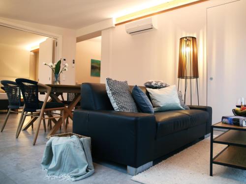 a living room with a blue couch and a table at SEE & THE CITY apartments in St. Wolfgang