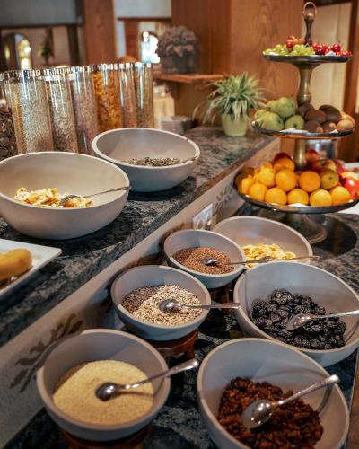 a buffet with bowls of food on a counter at Familotel Kindl in Neustift im Stubaital