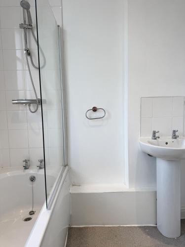 a white bathroom with a shower and a sink at 6 BR 4 Bath Central Worcester Sleeps 12 in Worcester