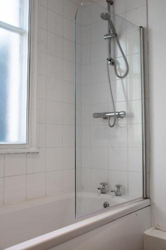 a shower with a glass door next to a bath tub at 6 BR 4 Bath Central Worcester Sleeps 12 in Worcester
