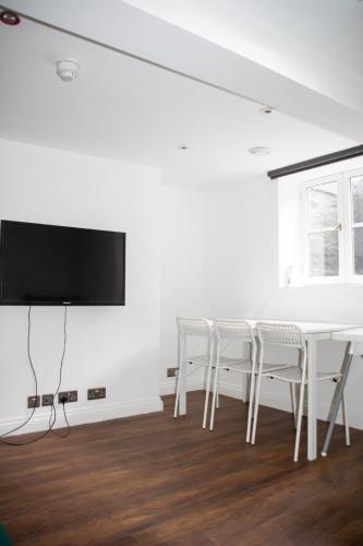 a white dining room with a white table and chairs at 6 BR 4 Bath Central Worcester Sleeps 12 in Worcester