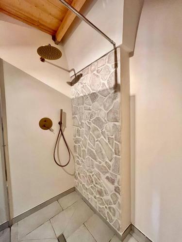 a bathroom with a stone wall with a shower at Dimore Mida in Brindisi