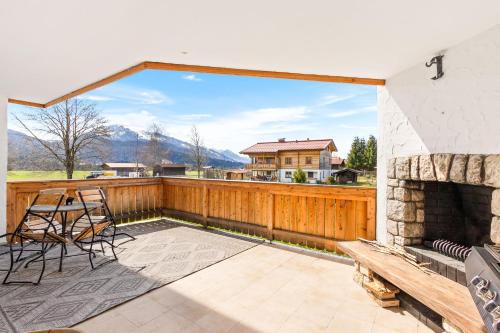 a patio with a fireplace and a table and chairs at Soho Mountain Chalet - Pool und Sauna in Reit im Winkl