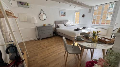 een slaapkamer met een bed en een tafel en een bed en een bureau bij Appartement rénové 250m du port - classé 3 étoiles in Honfleur