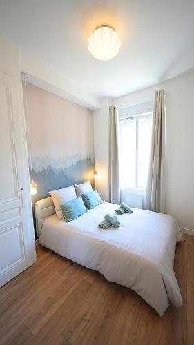 un grand lit blanc dans une chambre avec une fenêtre dans l'établissement Appartement cosy et design entre PartDieu et Charpennes, à Lyon