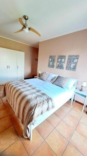 a large bed in a bedroom with a ceiling fan at Casa Frida in Menaggio