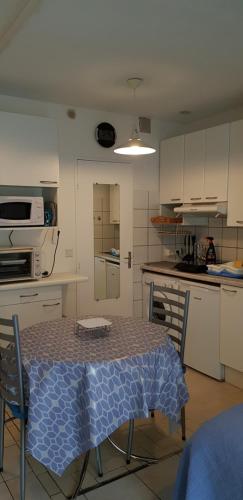 une cuisine avec une table et un chiffon bleu dans l'établissement Joli studio 43 avec vue sur les Dourbes 04, à Digne-Les-Bains