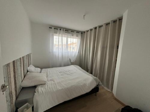 une petite chambre avec un lit et une fenêtre dans l'établissement Maison de charme 5 min de la plage, à Saint-Hilaire-de-Riez