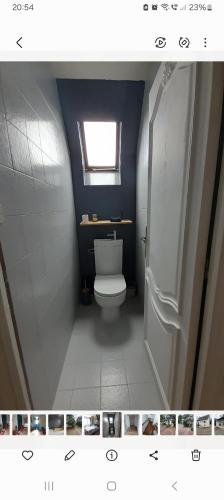 une salle de bain avec des toilettes blanches et une fenêtre dans l'établissement Belle maison proche du futuroscope, à Thuré