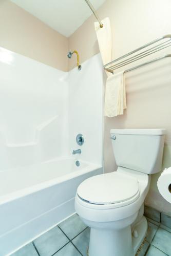 a bathroom with a toilet and a bath tub at Regency Inn By OYO Three Rivers in Three Rivers