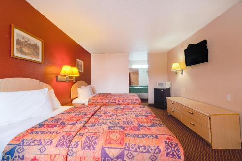 a hotel room with two beds and a flat screen tv at Regency Inn By OYO Three Rivers in Three Rivers