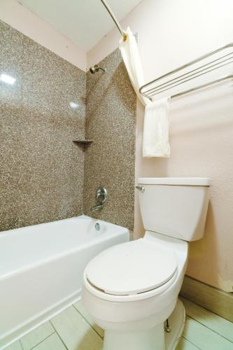 a bathroom with a toilet and a bath tub at Regency Inn By OYO Three Rivers in Three Rivers