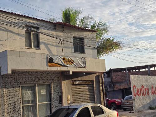 a building with a car parked in front of it at Pousada Piu-piuu Cajazeiras in Salvador