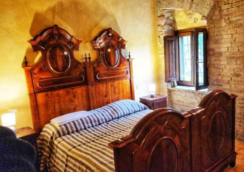 a bedroom with a large wooden bed in a room at Ca' Paradiso - Natura e Relax in Smirra
