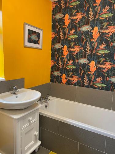 a bathroom with a sink and a bath tub and a sink at Two bedroom detached bungalow with conservatory in Bottesford