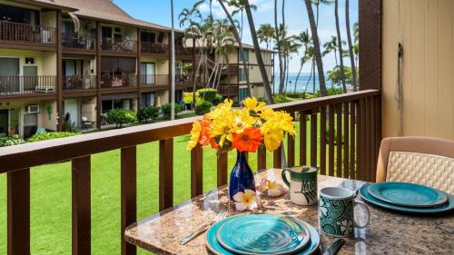 a table with a vase of flowers on a balcony at Kona Isle B22 in Kailua-Kona