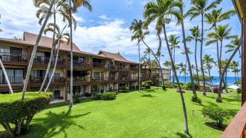 an exterior view of a resort with palm trees at Kona Isle B22 in Kailua-Kona