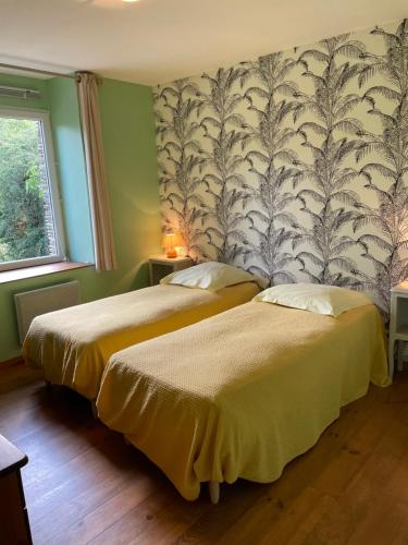 deux lits dans une chambre aux murs verts dans l'établissement Gîte rural Le Pressoir, à La Vacquerie