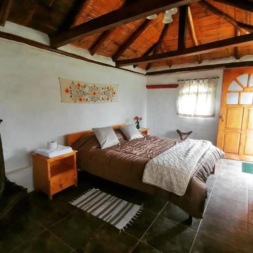 a bedroom with a bed and a wooden ceiling at Cabaña en la Montaña in Otavalo