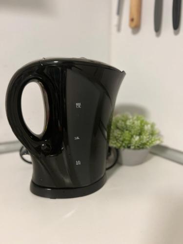 a black coffee cup sitting on a counter at Yellow Home in Lychen