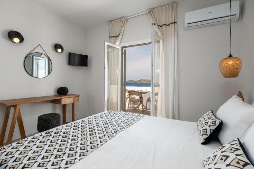 a bedroom with a bed and a view of the ocean at Sea & Sun Paros in Naousa