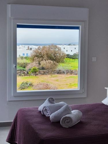 a bedroom with a window with towels on a bed at Amfitriti's Apartment in Naxos Chora