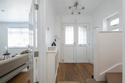 a hallway with white walls and a door in a room at The Romford Oasis - Spacious 4 bedroom escape in Havering atte Bower