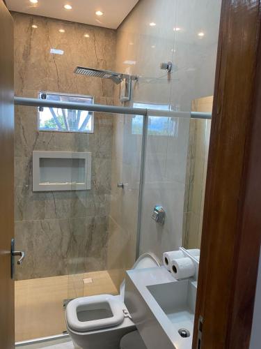 a bathroom with a shower with a toilet and a sink at Hotel Bonanzza Coxim in Coxim