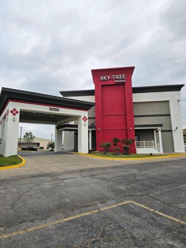 a large red building with a sky tire store at Sky Tree Hotels in Tulsa