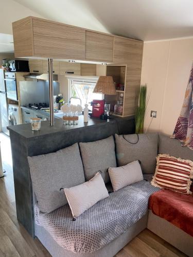 a living room with a couch with pillows at Camping 3 étoiles l'Albanou Chic in Le Pouzin