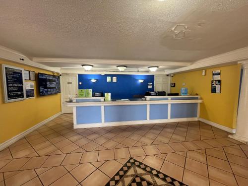 a lobby with yellow and blue walls and a counter at Studio 6 Huntsville, AL University Drive in Huntsville